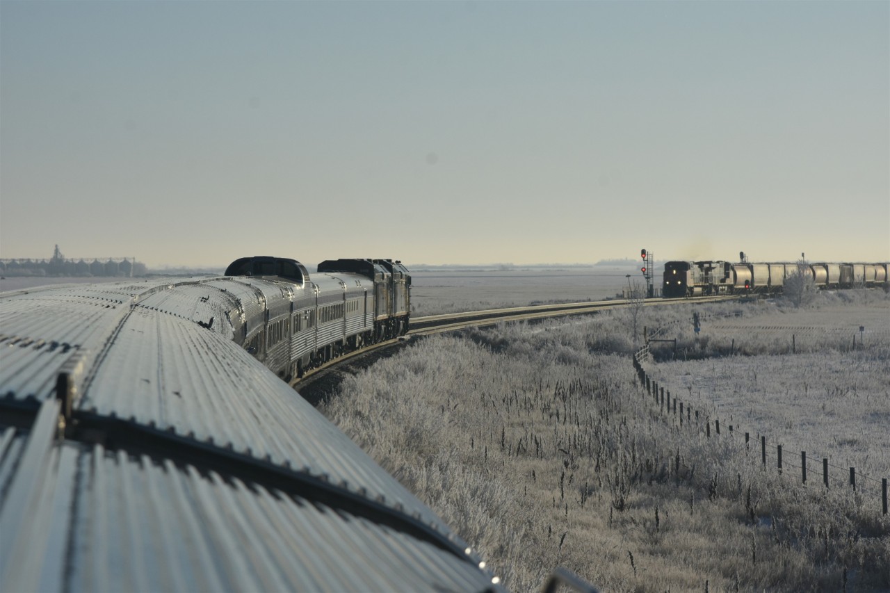 Prairie meet  
VIA 002 The Canadian is in the hole for a CN grain train on a frosty cold November 30, 2025 morning.