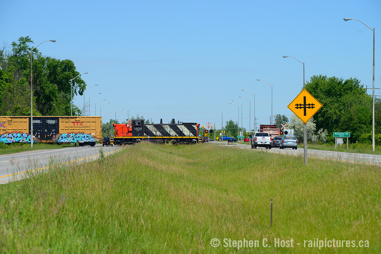 Not many railways cross what you may consider a 'divided highway' and this is one of the few spots in Canada. 
Pictured is CN 542 crossing Highway 6/7, the "Hanlon Expressway" in Guelph. Construction has begun on the new highway 7 finally, and this rail crossing will be closed in the not too distant future (about a year). In it's place a new connection west of Royal Road will be constructed to connect the North and South GJR industrial spurs (it will cross Massey road near Hood Packaging/Hastech). CN gave up/lost the traffic to Smurfit-Stone (Packaging plant) so they rarely cross here anymore, GEXR/GJR handles this work now