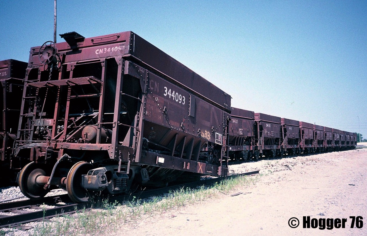 A string of retired veteran CN ore cars is shown awaiting their fate at the S Yard in MacMillan Yard in Vaughan, Ontario. The hopper cars were in the 344000 series, and most were over four decades old, having been built during the mid-1950’s.
