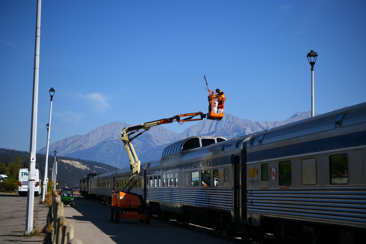 Sparkling Clean  
The Economy Class Skyline car gets its dome windows scrubbed and rinsed during a scheduled station stop in Jasper, AB. 
On a beautiful day like this, the clean windows will be a big plus for photographers as The Canadian continues its eastward journey out of Jasper, and out of the Rocky Mountains.