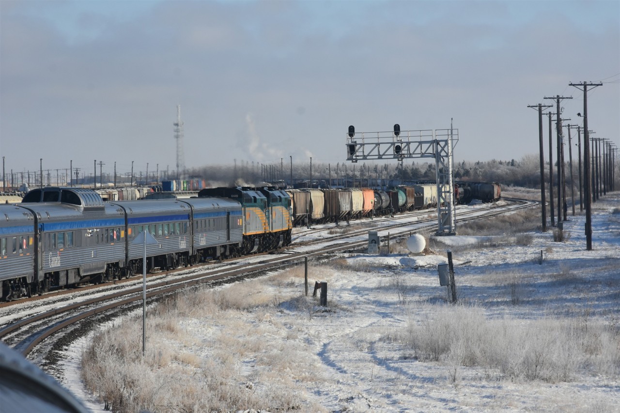 Skirting the yard >/b> 
VIA 6458 and VIA 6449 lead VIA 2 The Canadian around CN's Saskatoon Yard on November 30, 2025. 
Once it passes CN Chappell Jct. at the east end of the yard, VIA 2 will make a reverse move on to the station track where a full train servicing will take place. 
Passengers will have 30-45 minutes to detrain for some fresh air and a walk along the station platform.