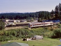 During the short period of Victoria Pacific tourist railway operation on a short section of CN’s Cowichan subdivision west of Victoria, one of my photo goals was to document CP’s E&N southward Courtenay-Victoria passenger train No. 2 with Victoria Pacific equipment in the background, ideally with sunlight on the near side.  Near the summer solstice, on Saturday 1972-07-01, that worked out, with CP 9199 on No. 2 and former Comox Logging & Railway 2-8-2 Baldwin number 16 getting ready to depart Millstream Junction on the last run of the day, as seen from up on the TransCanada Highway.