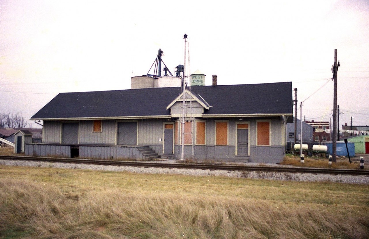This is an image of the old West Lorne CSX station. It had recently closed and remained in situ until the 1990s. Not sure if it as demolished or moved.
The station was constructed in 1893 for the Lake Ere & Detroit River Railway which eventually evolved into the Pere Marquette Railway before being swallowed by the CSX family.
It is interesting to note that all these little towns in SW Ontario along the line were important. West Lorne is an example of a community that was almost completely reliant on the railway for its commerce. Besides handling passengers and mixed freight, there was also yard tracks, a water tower and stockyards and a freight shed at this location. One could certainly see the importance of the railway since the automobile not even been  developed when this station opened for business.  (looks like an outhouse on the far left!!)
The station had name signs on each end but I elected to post this broadside view because the old water tower in behind identifies the location.