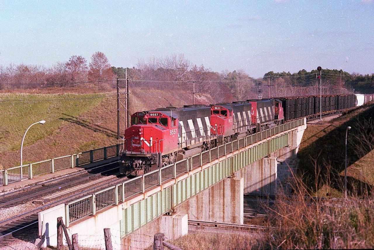 Three GP40-2L(W) as they were designated back in the late 1970s appeared to be everywhere. This image shows a westbound with CN 9557, 9633 and 9596 rolling over Hwy 403 about to climb Copetown Hill. It is early November, a great time to be wandering when the sun is still warm and the bugs have called it a year.
The problem I have with this location is:  Is it Burlington? Hamilton? Dundas? Flamborough?  I gave it the location of Hamilton West because the railroad name sign is just out of sight by the CN boxcar seen back in the train.