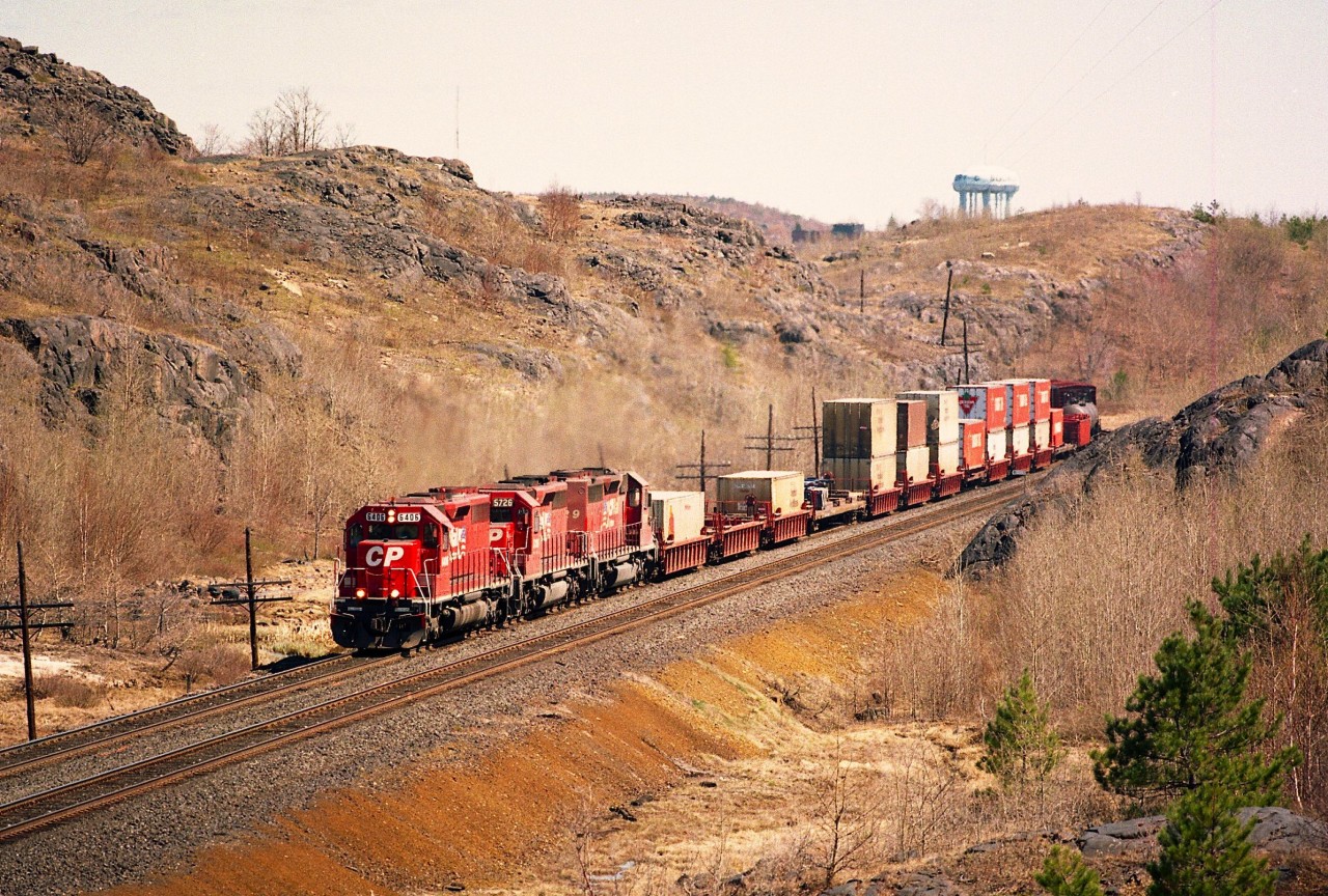 I'm parked along the side of La Salle Blvd just northwest of the Sudbury city limits.  I liked this location but parking was tricky. Busy road. Note the Sudbury water tower in the distant background. Something a bit different with this westbound train. An SD40A, 6406, is on the lead, followed by regular SD40-2 5726 and 5729. All five SD40A (6406-6410) designates were retired during 2001.