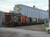 After their stint working passenger, commuter, local and transfer runs in the Southern Ontario area out of Spadina Roundhouse in downtown Toronto in the 50's and 60's, most of CN's 1900-series steam generator equipped GMD-1's migrated north in the early 70's to serve as switchers in Thunder Bay area out of Neebing Yard. Their steam generators were deactivated, and they were reclassified from GRG-12n to GR-12n units. Here, GMD-1 units 1912 and 1916 switch covered hoppers and grain boxcars at the Saskatchewan Wheat Pool's 7B grain elevator along Maureen St. in Fort William.<br><br><i>Original photographer unknown, Dan Dell'Unto collection slide.</i>