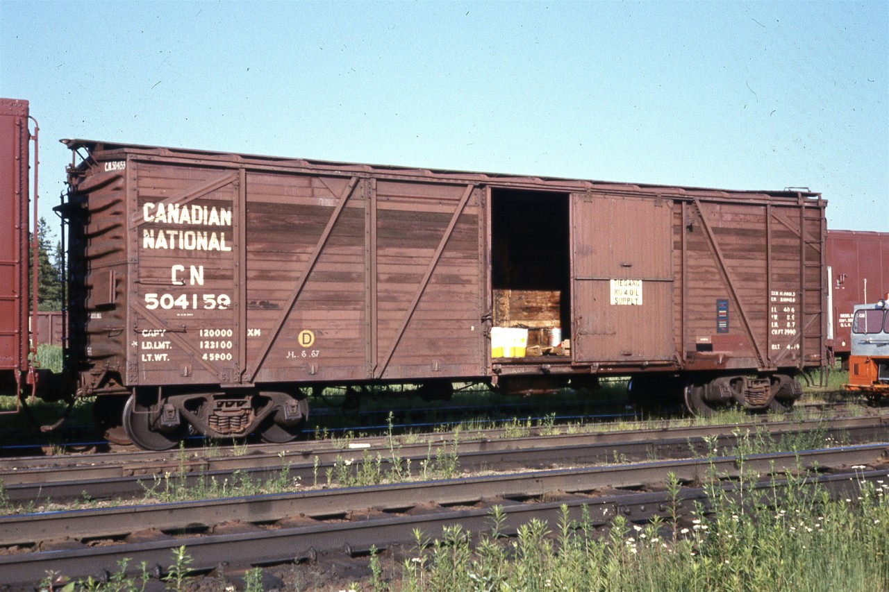 Long Service Award  
CN 504159 is the Oil Supply Car on CN's Great Lakes Region tie gang #4 at Oba, ON in July of 1976. 
This steel frame wood box car built in April 1929 is one of 1600 built by CC&F from March to May of that year numbered in the CN 503500-505099 series. 
It served CN well for 50+ years.