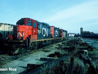 CN power is viewed idling in the Brantford, Ontario yard over the weekend with the station in the background. It includes; GP9RM’s 7030 and 7035 as well as GP40-2L(W) 9458. At the time, the Burford Spur was still active to Burford and all of Brantford’s active rail customers were serviced from this yard. 