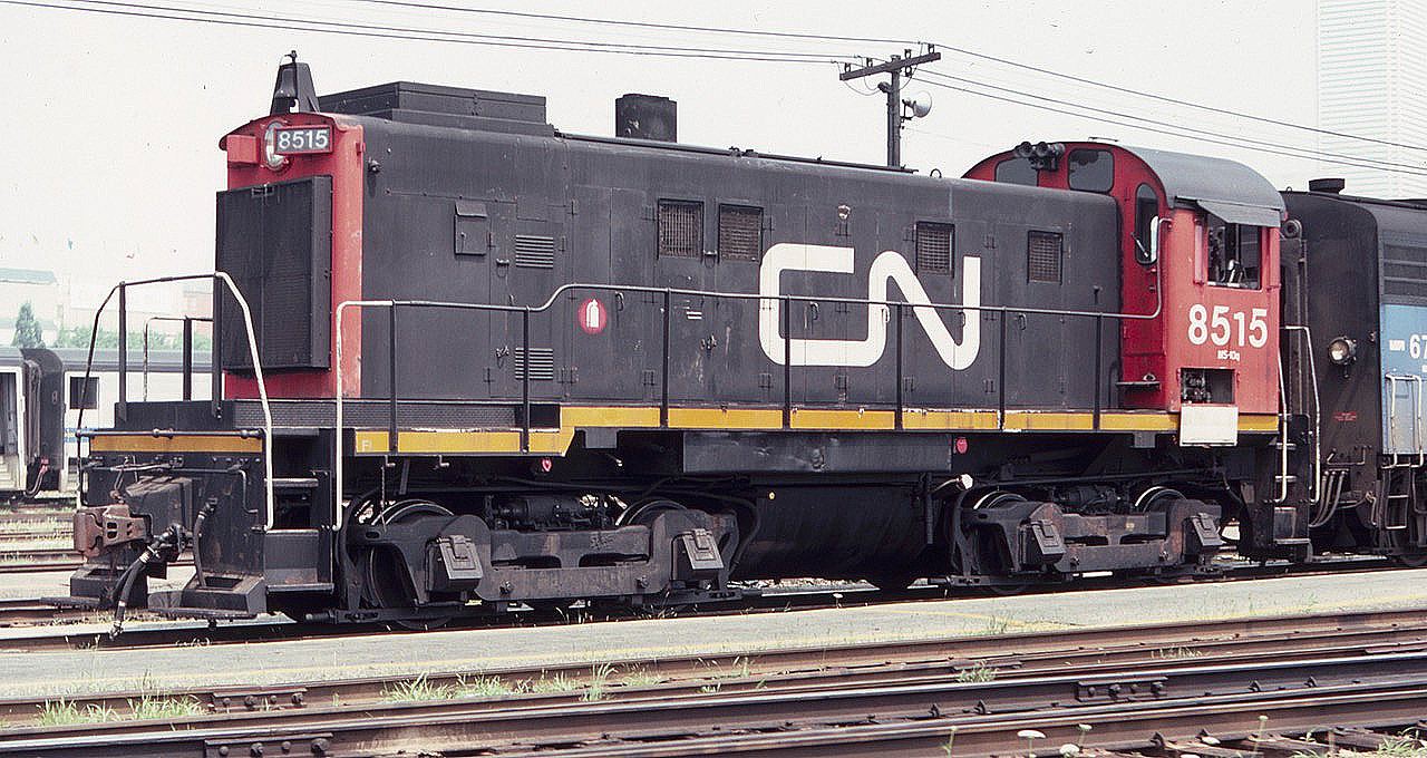 Another MLW S-13 switcher seen near Toronto Union Station in August of 1983, CN 8515, with the Bank of Montreal white tower barely visible in the background summer haze.