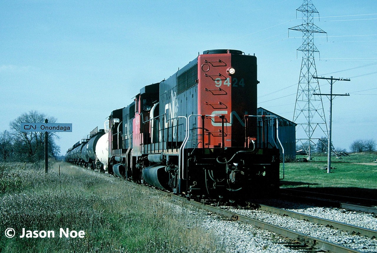 CN train 560 with GP40-2L(W)’s 9424 and 9508 are seen passing through Onondaga, Ontario as they head to Nanticoke on the CN Hagersville Subdivision from Brantford. This was the usual mid-90’s power for this assignment as it was typically powered by two or three GP40-2L(W)’s.