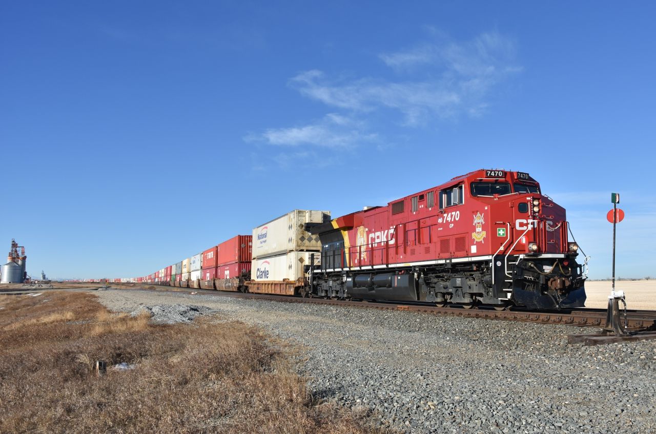 CP 7470 wearing the Lord Strathcona Horse Regiment coat-of-arms, leads a lengthy Eastbound double-stack (Possibly CP#100) at newly named station 'Golden Hills' with not a single hill in sight. This is just West of Carseland, Alberta.