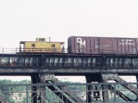 This photo of the C&O Chessie caboose was taken from the lower deck (vehicle traffic) of the Whirlpool Bridge over the Niagara River Gorge on US Independence Day, July 4, 1983, as we drove west into Canada. The Chessie train from Buffalo has left NY State and is entering Canada, headed westbound into Niagara Falls across the adjacent, upstream, Michigan Central Bridge.  The MC bridge is of course no longer used and the associated mainline tracks through Niagara Falls are no more. Those Detroit & Mackinac box cars were often seen.