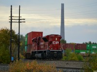 CP SD70ACU 7058, rebuilt from UP SD9043MAC 3551 (built 1/1997 as UP 8080), takes up the rear of CP 112 around the bend at the very top of the Parry Sound sub in Romford. While their sister "Super Stacks" in Sudbury are slowly being dismantled, one of the 2 "Twin stacks" built by Inco in 1954 and 1958 stands tall in the background.<br><br>Idled in April of 1972 due to stricter environmental laws, the Coniston plant was kept as a "standby smelter" (although it was never used again), until most of the site but the towers and some original buildings was demolished in 1976. They have stood as part of the "Coniston Industrial Park" and the town's identity ever since, briefly being studied for the feasibility of retrofitting the two dormant 120-metre tall smokestacks with wind powered generation systems in 2007, ultimately resulting in a windmill farm being built further South closer to the French River. 