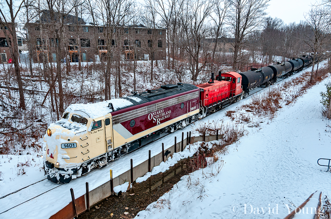 The first train since Christmas arrives in Tillsonburg with an odd looking pair of bedfellows leading the charge. Not known for frequenting the TBurg- OSR 1401, battered in snow bares evidence of battling the snow drifts left behind from the storm the week prior. Seen arriving into town from the new look CASO bridge this shot has opened up dramatically from years past. Too bad the old tell-tail didn't survive the make-over.