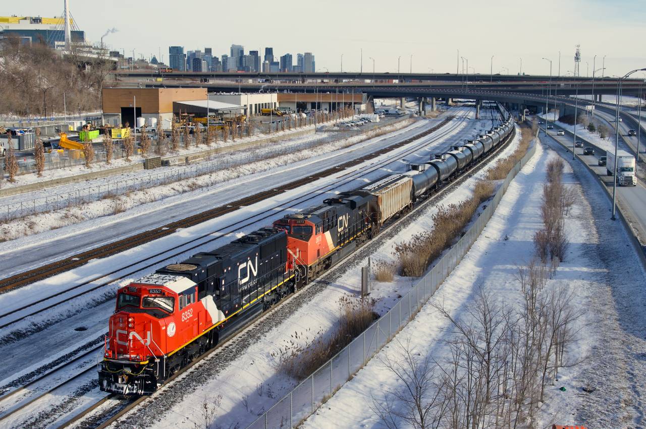 Empty ethanol train CN 713 passes the skyline of downtown Montreal on yet another freezing morning with fresh CN 8352 leading (CN 2873 trails).