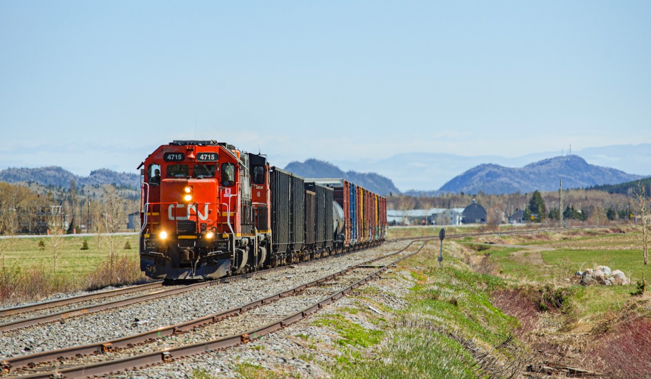 After hearing train 559 depart Mont-Joli with 4715 as the lead engine on my scanner that sunday morning, my friend Vincent and I quickly prepped up for a chase, as standard cabs don't lead trains often on the Mont-Joli subdivision. We stopped at many locations along the way, but the spot in Saint-Simon arguably brought the most interesting picture of the bunch, with the scenic mountains that we nickname ''The Walls'' visible in the background.
Being one of the rare GMD GP38-2s left on CN roster with its original bronze bell still intact, this chase was one of my favourites this year, not that i chase trains that often...