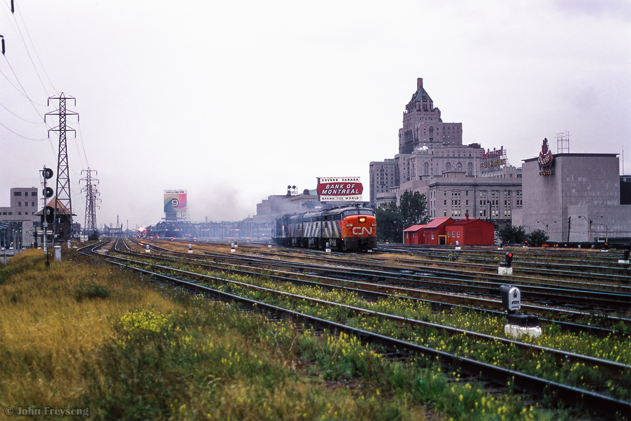 Threading the slip switches out of Union Station, four units lead this passenger train eastbound approaching Jarvis Street.  CPR Budd cars can be seen in the distance, along with TTR Scott Street Tower at left.

Scan and editing by Jacob Patterson.