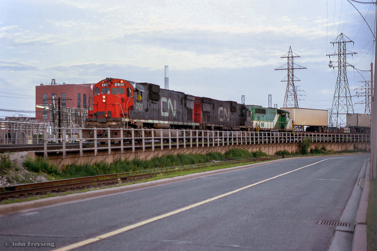 Swinging north onto the Bala Sub, a pair of big Ms and GO 706 lead a freight with TOFC traffic on the headend.  The lower track seen running along the old alignment of Bayview Avenue swings west to freight sheds at Cherry and Mill streets.

Scan and editing by Jacob Patterson.