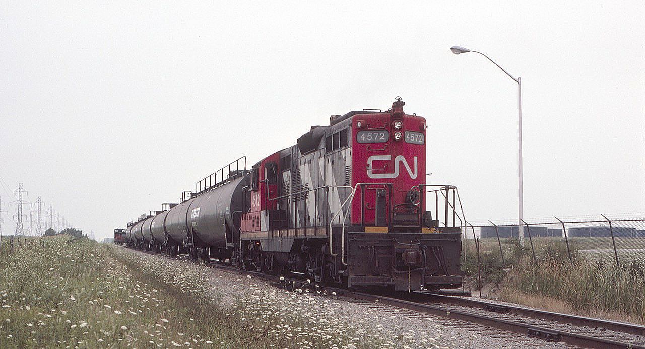 CN 4572, GP-9 is seen handling Procor tank cars just north of Nanticoke, Ontario, in August of 1985. Storage tanks are seen to the right, and the caboose is further back on the main. I was in Nanticoke for a tour of the Stelco plant as a metallurgical engineering student at the University of Texas at El Paso. My mother's cousin, Henning Christiansen of Hamilton, was a Stelco manager and arranged for the tour.