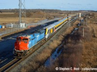 CN's Grand Trunk Heritage unit leads a P276 with a Siemens Venture delivery, rolling by the construction site of what is soon to become the Milton Intermodal Terminal. Chasing from Paris, it was cloudy all the way until Aldershot, when the sun came out, but the only chance of catching up to it would be a meet on the Halton. A meet indeed was scheduled at Ash, but they would wait almost an hour for the westbound to come, and a few minutes after it passed me on the bridge at  Brittania Road the sun basically disappeared for good. This scene has been further changed as the CN overpass is now complete, and track installation for the new terminal should be continuing into Spring 2026.