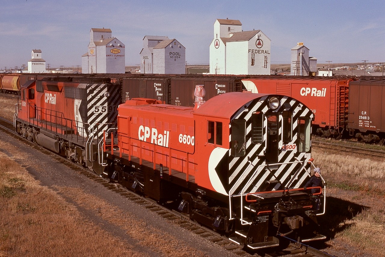 Canadian Pacific generally overhauled switcher units at Weston shops in Winnipeg, and shipped them dead back to their home terminals.  On Tuesday 1974-10-01, a westward train with CP 5591 has brought essentially spotless MLW S-3 6600 with wrapped stack  to the shoptracks, seen here from the Second Avenue road overpass.