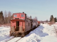 Twice-weekly (Tuesday and Friday) freight train No. 65 from Wellcox yard in Nanaimo has just arrived Courtenay with back-to-back Baldwins CP 8001 and 8010 and caboose CP 437030 (with marker lamps already positioned for the return trip) on Friday 1975-02-14 and is preparing to switch its train.  On the left, snow outlines where a wye had been until removed a few years ago.  With no timetable schedule for southward freight trains, the return to Wellcox will be as an Extra.
