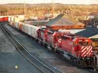 I knew we had a train coming. The question was, would it beat the sunset?  Yes, but just barely. The town was falling to the shadows as CP 5944, 5504 and 6408 are about to power a container train westbound as soon as the crew changeover business is complete.
The station/office is the flat roof building on the right.