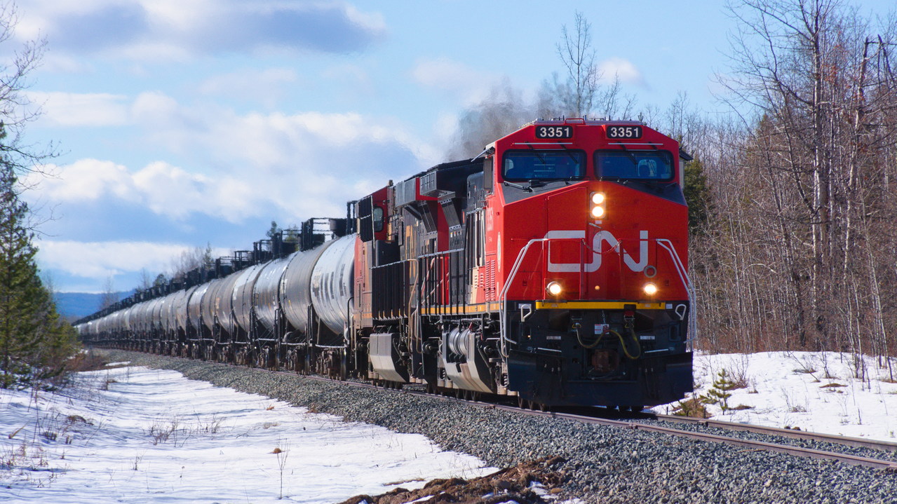 A newly rebuilt CN AC44C6M leads L57551 on a beautifully sunny day.