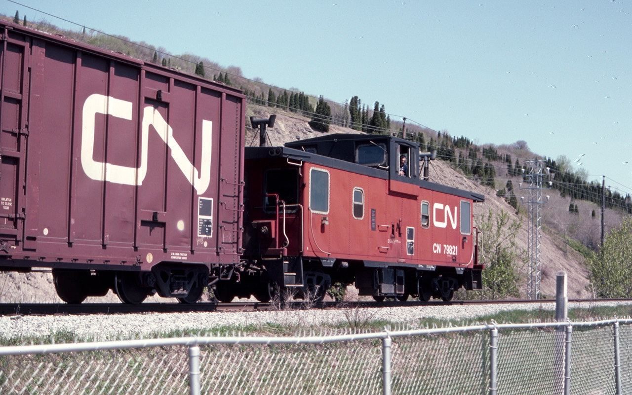 Just after arriving at Montmorency Falls, PQ, on a school trip, a westbound freight train passed the falls in May of 1982. CN caboose 79821 brought up the rear. I waited by the tracks for another train and did not go in to see the falls. Alas, I did not realize that this line, the Murray Bay Sub, was not a CN mainline. There is a tourist train there now - I should go back and see the falls.