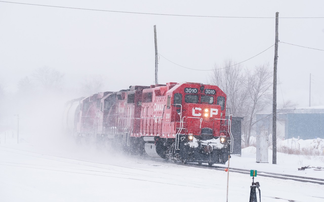 During an inclement snow storm, CP's turn from London heads east into Woodstock with three four-axles up front. They will drop cars for interchange with the Ontario Southland in West Coakley before lifting their cars for London and flipping back west. Points for the GP38AC leading donning clean bank gothic paint.