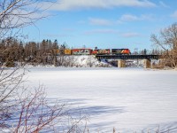 CN 561 travels over the Mitis river in Price with the usual 2 locomotives in charge. The 3rd locomotive was dropped in Mont-Joli as they would only service the paper mill in Matane that day, maybe they had problems with the ferry, who knows? Behind the bridge, barely visible, sits the Mitis-1 dam and power generating station.