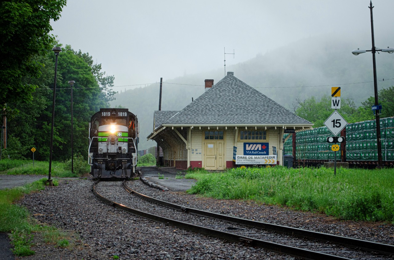 SFG 565's engines crawl past Matapédia station on a foggy Monday morning as they ride on CN's trackage to interchange cars for and from CN 562, before heading to New Richmond. On the right, you can see the cars that they dropped off, and in the background, the cars that they are about to pick up.