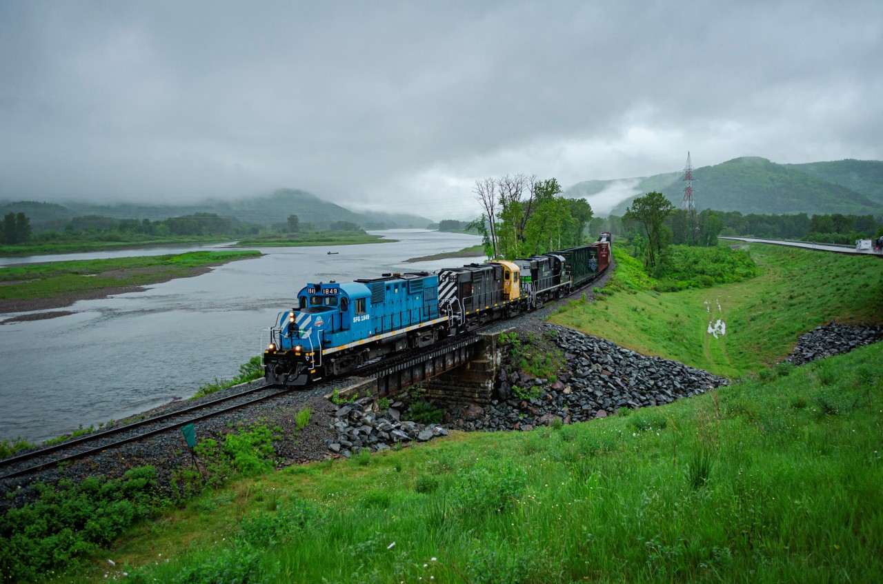 Former tourist train L'Amiral RS-18u #1849 leads the Monday Matapédia - New Richmond run on a foggy morning through the old town of Sillarsville, now part of Ristigouche-Sud-Est. It is very common to be greeted by fog when driving through the Ristigouche river valley at this time of the day.