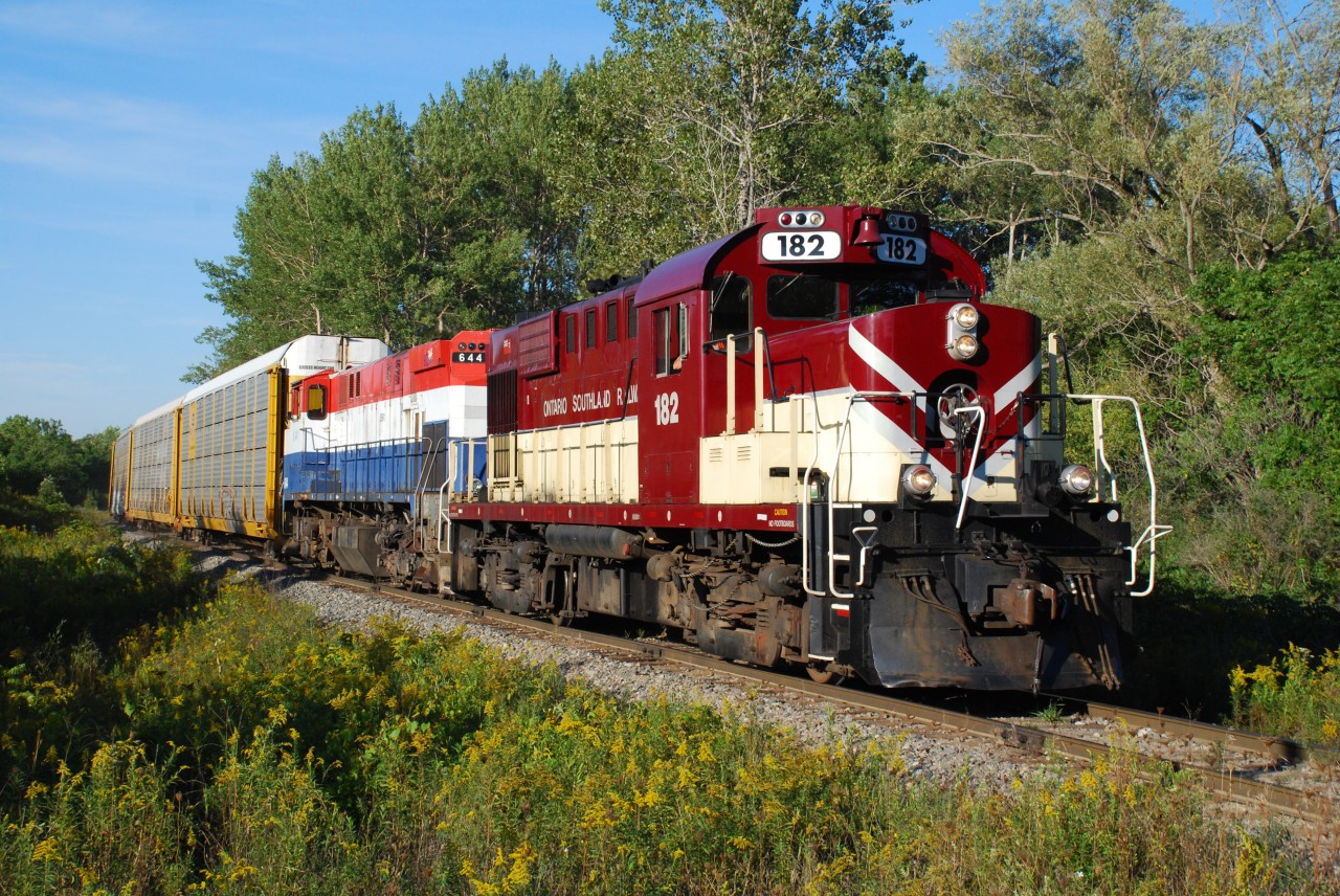Ontario Southland Railway 182 and 644 approach Domtar Line west of Beachville with a long string of racks for Cami in tow. Late January, 2026, OSRX 182 departed Salford for the last time enroute to it's new owner, the Chemin de fer Sartigan. Back in 2020 OSRX 644 and the other three M-420(W) were sold to the CFS also, so soon it may be possible to photograph these same two locomotives together again on the Sartigan in Quebec.