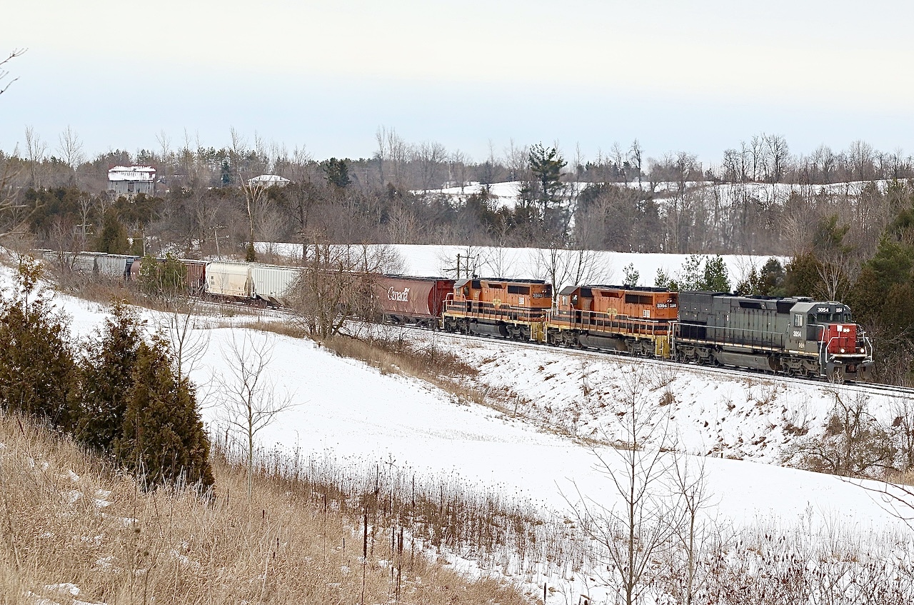 Growing up my family spent a lot of weekends at a campground outside of Acton. Some of my favourite memories are of evenings spent at the campfire listing to distant trains battling the Niagara Escarpment as they headed westward, along with horn echoing through the hillsides. In later years after the camping ended o spent more time exploring CN’s Guelph subdivision around Acton, my day shift ending time often allowed me to chase Goderich Exeters train 431 as it daily battled the Escarpment. This spot for me was a hidden gem often overlooked by a lot of railfans, mainly due to the sun never being in the right location to illuminate everything properly. Cloudy days were preferred here. The sound of the six axle EMD’s fighting the grade was like no other, and they often lost the battle. Unfortunately time rolls on, and CN took back the operations from GEXR  and this end of the subdivision was sold to Metrolinx, with CN becoming a tenant and all freight movements this side of Acton became nocturnal. Today CN still battles the Escarpment but under the cover of darkness. Here GEXR train 431 with my favourite “Tunnel Motor” in the lead is seen heading into Acton under dreary skies.