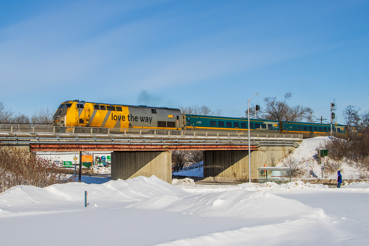 An LRC set in Ottawa? Leaving in daylight, and the sun is actually out?
Unlike some equipment... there was no question whether this veteran consist would have any difficulty with the -11°C air temperature this morning. At exactly 0935, the spooled-up prime mover in P42DC 919 was audible from my snowbank perch, as VIA #43 departed right on time. A moment later it had completed the "hard left" leaving Ottawa station westbound, with LRC clubs 3473 and 3471, and coaches 3361, 3324, and 3353. This bridge carries the Beachburg Subdivision over a connection to the bus-only Transitway, used by OC Transpo buses accessing Hurdman station.
Normal can become boring until it suddenly isn't normal anymore. A view just like this could be anytime in the last decade or so. Change the paint (or wraps) and this could be anytime in the last 25 years. With a different locomotive (and yes, searchlight signals), this could be 40 years ago. Today, Ottawa sees one LRC consist per day, maybe. It is usually a late evening arrival from Toronto, turned and sent back early the next morning. (This one was #54 the evening before.) With few decent accessible locations in the city, and awkward light angles for most of the day, it's getting very hard to catch these.
The LRC fleet is dropping off fast. If you are near the corridor, go shoot these while you can. P42s too - they may not be popular now, but the sentiment will change later. When F40s first proliferated across North America, we begrudged them for what they replaced. Thanks to VIA's rebuilds, we still have their familiar presence up here, but Amtrak fans now wax nostalgic for them. The GE Genesis line subsequently became ubiquitous passenger power, and soon they will be gone too. Don't take them for granted. I may have a few more chances to try this, but pretty soon it will be unrepeatable.