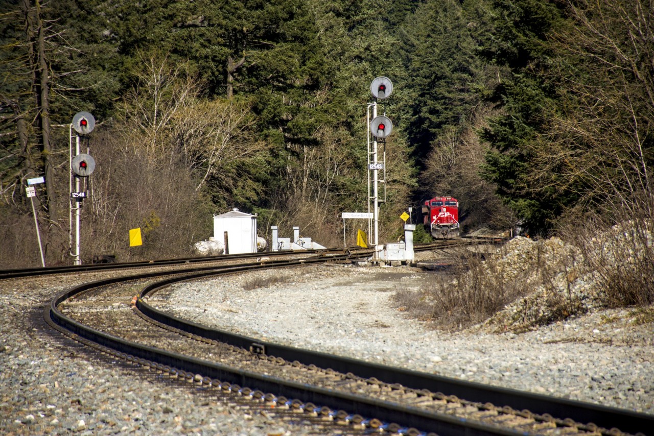 A CPKC coal train waiting to get the light in Boston Bar on the CN Yale Sub. A CN intermodal had just passed with the addition of a fresh crew, and this train was presumably doing the same, with a CPKC crew change van waiting off to the side.