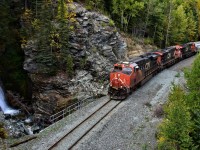 CN A47521 rounds the curve by Bijoux Falls, just over the summit of the Pine Pass. This train is headed towards Prince George in some great fall colors. To get to this location, a 8-10 minute hike is required, up very steep and wet rocks/logs, and then on top of that, I was standing up on a large rock cut that overlooked the tracks, and the top of the falls, which go down quite a ways on this side of the tracks. A good stop!