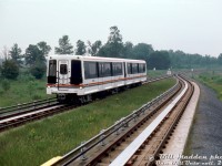 Operating on trackage but not in Toronto, TTC ICTS cars 3009 and 3008 operate at Urban Transit Development Corporation's Millhaven Ontario facility, running on the test track within the grounds (this appears to be at the south end of the property, along Taylor Kidd Blvd). Part of the new Intermediate Capacity Transit System (ICTS, in between a streetcar and subway) that crown corporation UTDC hoped would take hold (it didn't, outside of a few systems), the TTC bought into the government's new system in the early 1980's for their new Scarborough Rapid Transit (SRT) line, that would have otherwise been run using streetcar/LRV technology.
<br><br>
An orphan system over the years, the SRT line and equipment would be run beyond their lifespan due to political meddling for a replacement line: the Transit City LRT plan in place and fully funded that would have replaced the SRT was cancelled by new mayor Rob Ford in 2010 in favour of "subways subways subways" (which resulted in years of typical political squabbling around length, route, funding, costs), that years later still hasn't been built.
<br><br>
The SRT managed to cling to life until July 2023, when a derailment in service finally put the nail in the coffin and an end to the entire system in Toronto. Scarberians are now taking shuttle buses on the former RofW while construction for the line continues on, 16 years after the original replacement plan was cancelled. One old SRT car is preserved at the HCRY, while another is at the Toronto Zoo, and the bulk of the cars were sold to Detroit for reuse on their own ICTS "People Mover" system.
<br><br>
<i>William (Bill) J. Madden photo, Dan Dell'Unto collection slide.</i>