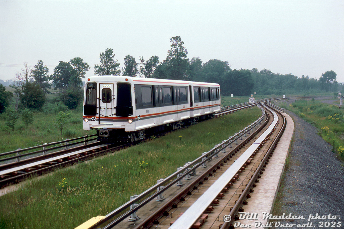 Operating on trackage but not in Toronto, TTC ICTS cars 3009 and 3008 operate at Urban Transit Development Corporation's Millhaven Ontario facility, running on the test track within the grounds (this appears to be at the south end of the property, along Taylor Kidd Blvd). Part of the new Intermediate Capacity Transit System (ICTS, in between a streetcar and subway) that crown corporation UTDC hoped would take hold (it didn't, outside of a few systems), the TTC bought into the government's new system in the early 1980's for their new Scarborough Rapid Transit (SRT) line, that would have otherwise been run using streetcar/LRV technology.

An orphan system over the years, the SRT line and equipment would be run beyond their lifespan due to political meddling for a replacement line: the Transit City LRT plan in place and fully funded that would have replaced the SRT was cancelled by new mayor Rob Ford in 2010 in favour of "subways subways subways" (which resulted in years of typical political squabbling around length, route, funding, costs), that years later still hasn't been built.

The SRT managed to cling to life until July 2023, when a derailment in service finally put the nail in the coffin and an end to the entire system in Toronto. Scarberians are now taking shuttle buses on the former RofW while construction for the line continues on, 16 years after the original replacement plan was cancelled. One old SRT car is preserved at the HCRY, while another is at the Toronto Zoo, and the bulk of the cars were sold to Detroit for reuse on their own ICTS "People Mover" system.

William (Bill) J. Madden photo, Dan Dell'Unto collection slide.
