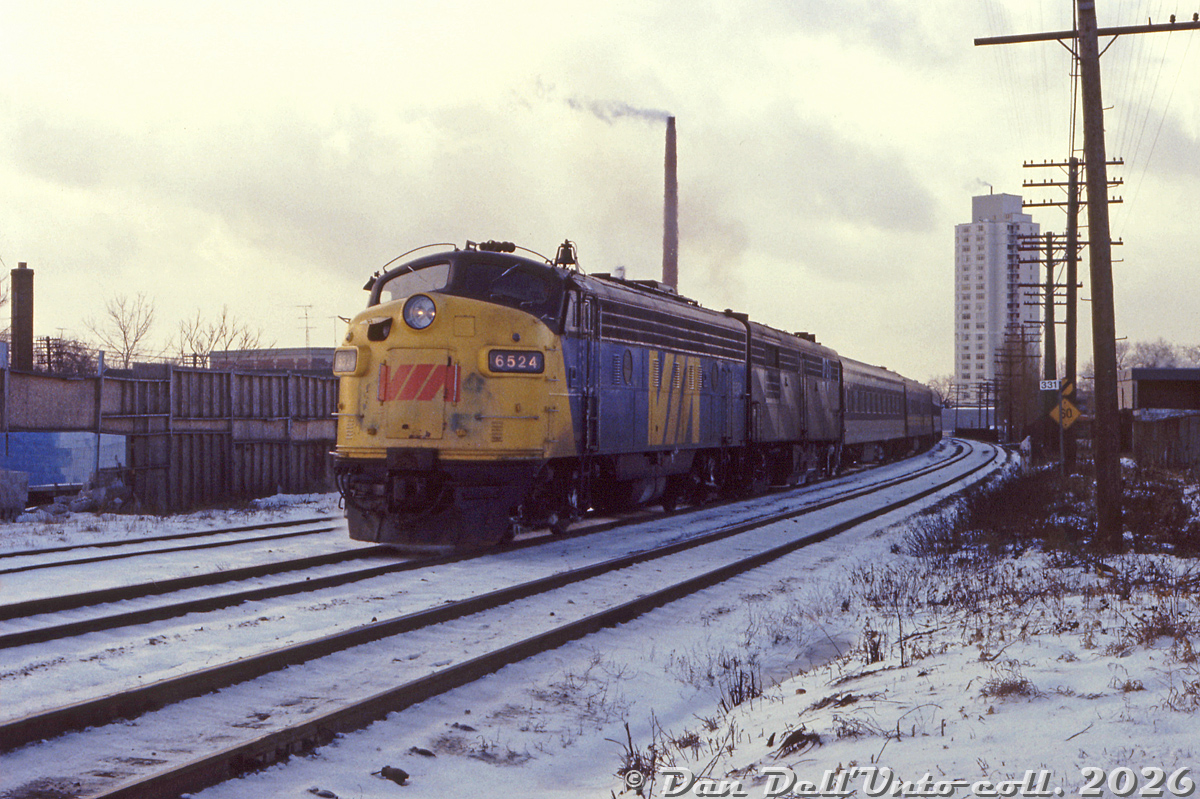 On a cold January 1979 day in east end Toronto, VIA FP9 6524 and an ex-CN 6800-series FPB4 head an eastbound passenger train on CN's Kingston Sub at Mile 331, around Gerrard Street East underpass. This was likely shot at or near the old Pape Avenue grade crossing, not too long before it was eliminated for a pedestrian bridge. The tower in the background is the Ray McCleary Towers at 444 Logan Avenue.

Original photographer unknown, Dan Dell'Unto collection slide.