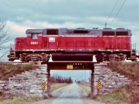 Bridging the gap. So much branchline railroading has vanished from Southern Ontario over the last few decades. It is nice to see, even today that the GEXR still has some nice rural trackage left, including some old photographic bridges. This shot was taken almost twenty years ago but most of the surviving trackage still looks the same. Unfortunately it’s hit and miss as far as catching a train. When the original GEXR started up in the early 1990’s many days you could still catch at least two trains running on its lines. Later that was lowered to basically one, and today, many days out of the week no train can be found along the rails west of Stratford. Here a typical consist for the time is slowly making its way over an old road bridge and through the rural countryside west of Stratford. 