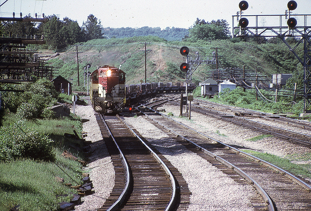 Here's a shot from 50 years ago at a location I seldom frequented. I am trackside at almost below Hamilton's High Level Bridge. Wandering along, I was caught off guard by what I considered at the time an early edition of  that daily Toronto to Hamilton and return Starlite. TH&B 72 is leading in this scene in which the train is on the CN to CP connector which enables it to access Aberdeen Yard in Hamilton's west end.
Note the track side shanties. There used to be so many of these. Small ones held tools and wayside equipment whereas in larger ones the maintenance guys could store their putt-putts (speeders). All now relics of the past.