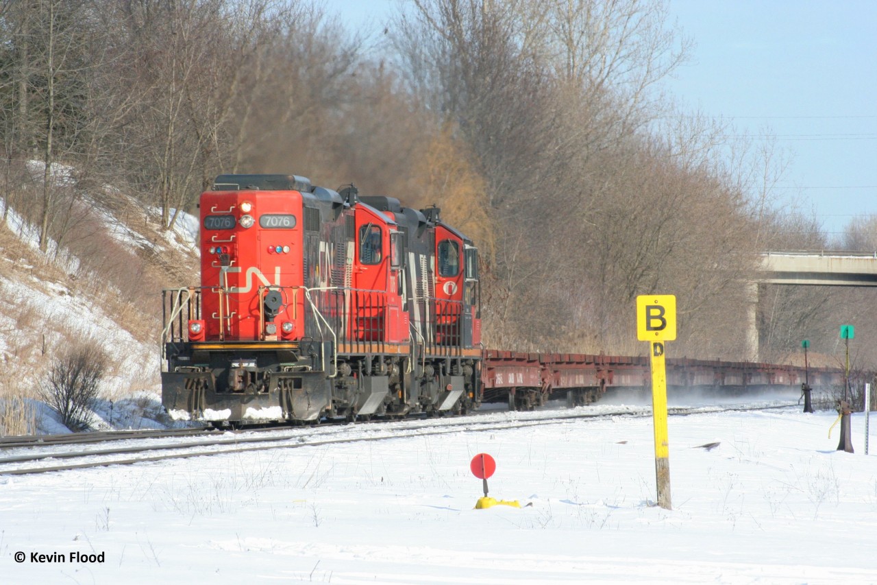 CN GP9s 7076 and 41xx power a movement of steel flat cars upgrade at Copetown, ON on February 16, 2008. Not sure what this train ID was.