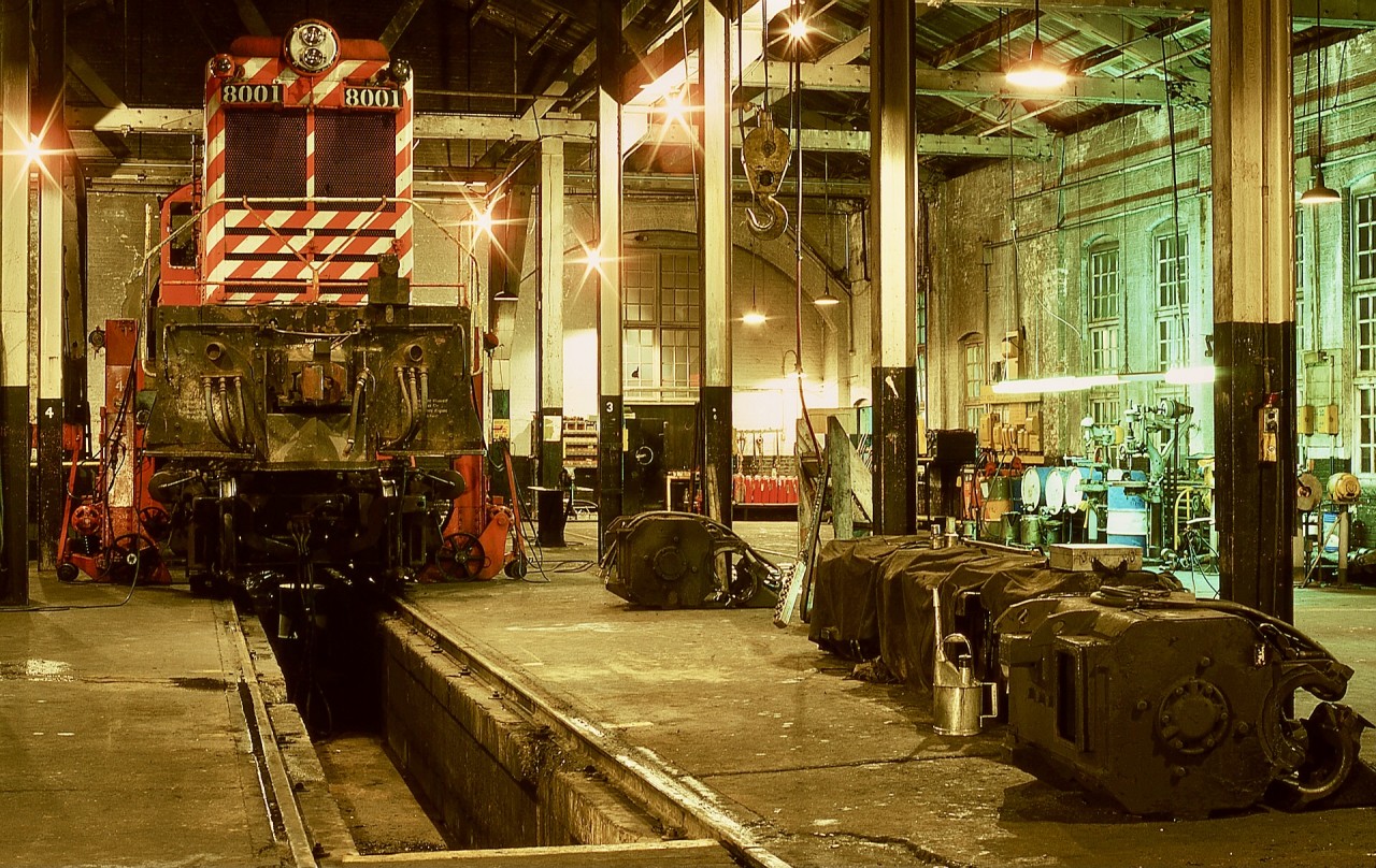Hoisting a locomotive on jacks to allow a truck to be moved out for a traction motor change was a regular work procedure at the CP/E&N backshop in Victoria, but the pictured one of Baldwin CP 8001 on Saturday 1975-03-01 carries special significance.  Just ten days later came instructions to shut down all CP Baldwin roadswitchers (seven remaining of the original thirteen after various mishaps) after twenty-six years of being maintained in that shop, so 8001 was the last to ride those jacks.

As a three-year employee there at that time, that hurt, and I often wondered what the longer-service folks (some of them well over half their careers) felt.