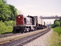 Many of us are frustrated by the strict control of property around the railroads. Fencing and No Trespassing signs, along with high quality cameras, are getting to be the norm. I thought posting this image might help clarify what has transpired over the years.
In this image, CN 8169, an MLW S-4, is in process of 'wyeing the pigs'. a daily (almost) procedure in which TOFCs are run around the wye in order to be in the correct position at the loading docks in Hamilton.
The engineer has just run the wye and he is now waiting for the signal in order to back the train into Hamilton.
Note there is a green signal on the right for a movement up the Dundas. Note the people on the tracks paying no attention whatsoever to potential danger on both tracks.
Railroads had to put up with this for years.   No more.
