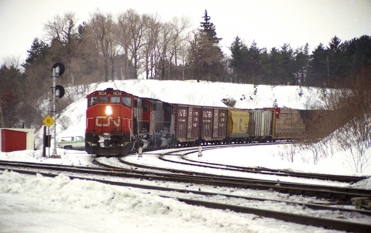 Just another winter's day hanging out at "The Junction."  Sitting somewhere warm, like in the car, a green goes up for an eastbound 'off the hill' so I scurry over to the south side in anticipation. A freight shows, seen about to enter the Oakville sub at the Junction with a trio of GP40-2L units, 9634, 9597 and 9565. I count off 60 cars and record the van as #79768. Mildly disappointed the power wasn't a little more of the unusual variety, but hey, there is always another train.
