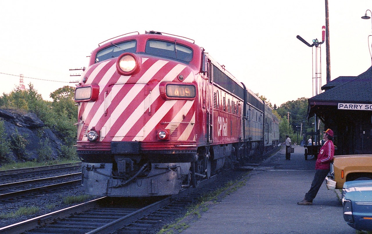 Since Parry Sound often appears to "roll up the sidewalks" after the dinner hour; one guy found a good way to pass the time. Head for the CP station and watch the trains come in.  It is rather late in the evening for the Super Continental #3 to be arriving at the station.  It's scheduled time was around 1800, and from the sun angle it is well past that.  But still bright enough for a decent image.  Power is CP 1409 and VIA 1961 with a fairly long train, considering it meets up with the Montreal section at Sudbury.
The CP 1409 was rebuilt into VIA 6557 in 1982.