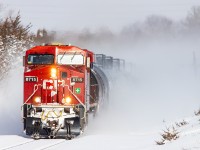 CP 8715 kicks up almost 40cm of fresh snow as it blasts through Trenton on it's trip west.