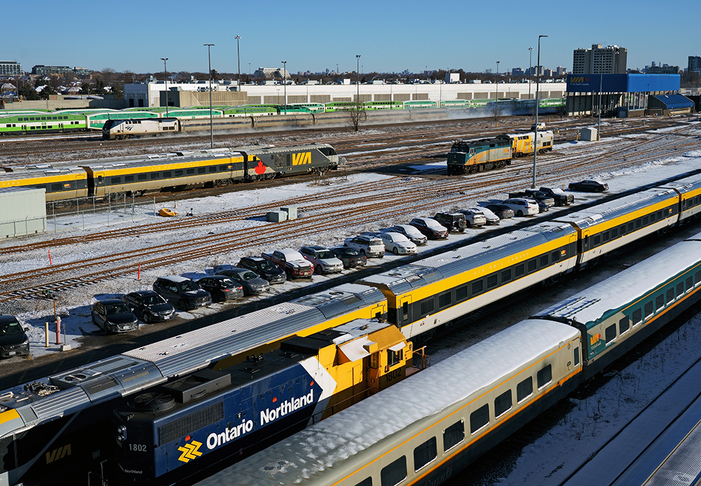 It's a cold morning in Toronto as VIA 97 zips past an assortment of parked equipment at VIA's Toronto Maintenance Centre and GO Transit's Willowbrook Yard.